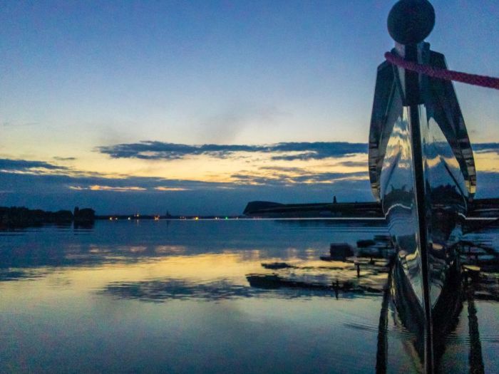 Ruderboot-Bug im Abendlicht spiegelt sich auf glattem Wasser.