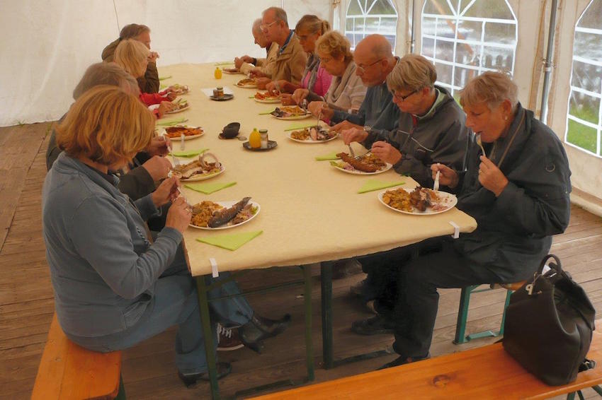 Menschen an einem großen Tisch beim Essen.